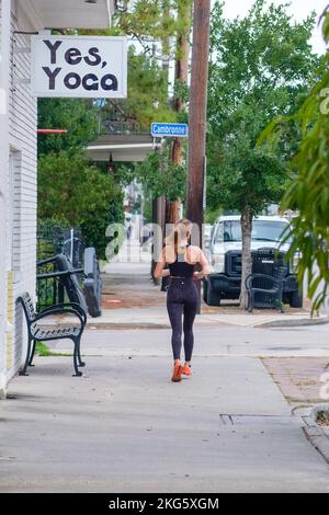 NEW ORLEANS, LA, USA - 25. JANUAR 2021: Frau in ihrem Workout-Outfit läuft am Eingang zu Yoga in der Oak Street in Uptown vorbei Stockfoto