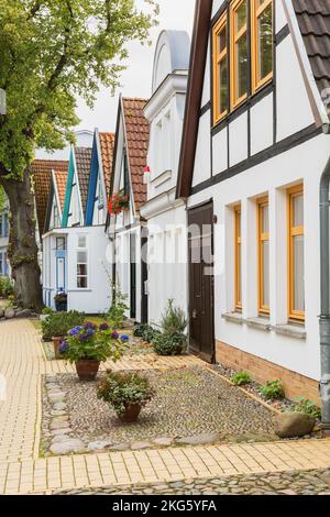 Wohnstraße mit bunten Hausfassaden und Terrakottadächern, Badeort Warnemunde im Bezirk Rostock. Stockfoto