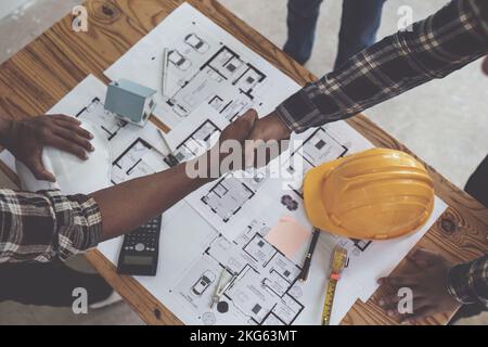 Architekt und Ingenieur Bauarbeiter schütteln Hände nach Abschluss einer Vereinbarung auf der Bürobaustelle, Erfolg Zusammenarbeit Konzept Stockfoto