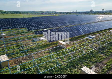 Luftaufnahme eines großen im Bau befindlichen Elektrizitätswerks mit vielen Reihen von Solarmodulen auf Metallrahmen zur Erzeugung sauberer elektrischer Energie Stockfoto