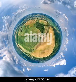 Luftaufnahme aus großer Höhe des kleinen Planeten Erde mit grünen und gelben bebauten landwirtschaftlichen Feldern mit wachsenden Kulturen an hellen Sommertag Stockfoto