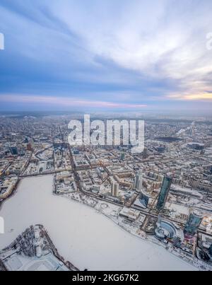 Jekaterinburg-Stadt mit Gebäuden der Regionalregierung und des Parlaments, Dramatisches Theater, Iset-Turm, Yeltsin-Zentrum, Panoramablick bei Sonnenuntergang im Winter Stockfoto
