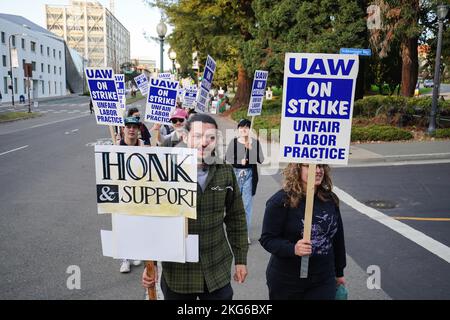 Berkeley, Usa. 21.. November 2022. Demonstranten halten Plakate während der Demonstration an der University of California Berkeley. Studenten Forscher und Arbeiter der University of California haben seit Mitte November 2022 geschlagen. Die Streikenden behaupten, dass der Lohn nicht fair sei und nicht ausreicht, um in Kalifornien zu leben. Sie wollen die University of California zwingen, ihre Löhne durch Streik und Demonstration zu erhöhen. Auf dem Campus der University of California in Berkeley begannen die Streikenden in der zweiten Woche ihren Streik. (Foto von Michael Ho Wai Lee/SOPA Images/Sipa USA) Quelle: SIPA USA/Alamy Live News Stockfoto