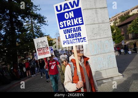 Berkeley, Usa. 21.. November 2022. Demonstranten halten Plakate während der Demonstration an der University of California Berkeley. Studenten Forscher und Arbeiter der University of California haben seit Mitte November 2022 geschlagen. Die Streikenden behaupten, dass der Lohn nicht fair sei und nicht ausreicht, um in Kalifornien zu leben. Sie wollen die University of California zwingen, ihre Löhne durch Streik und Demonstration zu erhöhen. Auf dem Campus der University of California in Berkeley begannen die Streikenden in der zweiten Woche ihren Streik. (Foto von Michael Ho Wai Lee/SOPA Images/Sipa USA) Quelle: SIPA USA/Alamy Live News Stockfoto