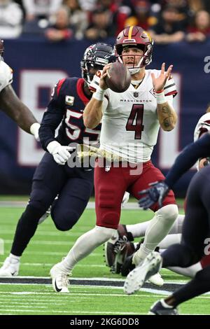 Der Quarterback der Washington Commanders Taylor Heinicke (4) setzt sich mit Houston Texans Defensive End Jerry Hughes (55) zusammen, um während der NFL Druck auszuüben Stockfoto