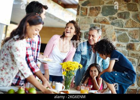 Es ist Zeit zu essen. Eine glückliche Familie genießt eine gemeinsame Mahlzeit. Stockfoto
