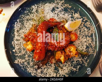 Blick von oben auf Fischgerichte mit Tintenfisch in roter Chilisauce Stockfoto