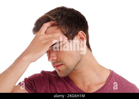 Zu viel Druck für einen schönen Mann. Ein hübscher junger Mann, der Schmerzen und Druck in seinem Kopf ausdrückt – isoliert auf Weiß. Stockfoto