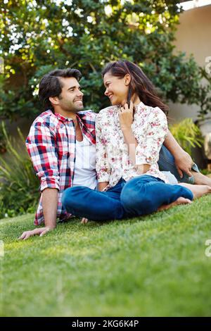Es sind die kleinen Momente, die wir schätzen. Ein glückliches junges Paar, das gemeinsam Zeit im Garten verbringt. Stockfoto