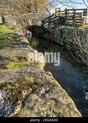 Fell Foot Bridge - eine alte Schiefersegmentbrücke mit einem Bogen über den Fluss Brathay, Little Langdale, English Lake District, Cumbria, England, VEREINIGTES KÖNIGREICH Stockfoto