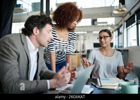Der Erfolg ist verdient. Büromitarbeiter, die in einer Besprechung im Büro sprechen. Stockfoto