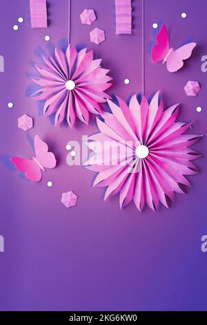 Papierfächer, Schmetterlinge, Blumen, Geschenkbox und Kerze. Flaches Lay mit Frühlingsornamenten, Dekorationen, Geschenkbox auf leuchtendem magentafarbenem Hintergrund. Geburtstag Stockfoto