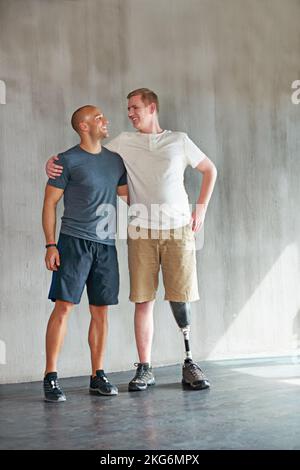 Ich bin stolz auf Euch. Studioaufnahme eines jungen Amputierten, der in einem Fitnessstudio trainiert. Stockfoto