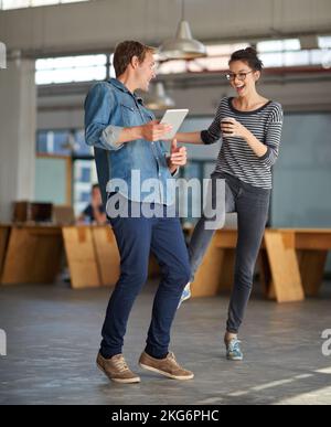 Zeit im Büro für ein paar Scherz herum. Eine junge Frau scherzte einen überraschten männlichen Kollegen. Stockfoto