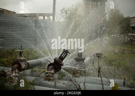 Wasser fließt aus dem gebrochenen Rohr. Durchbruch in der Pipeline. Unfall in der Kesselstation. Wasserfluss. Stockfoto