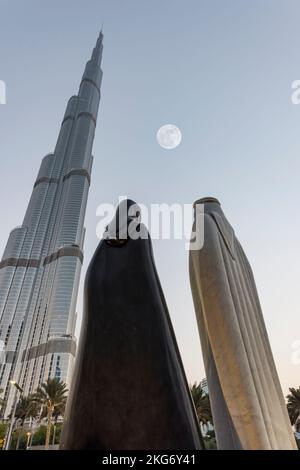 'Zusammen' Statuen, entworfen vom syrischen Künstler Lutfi Romhein mit dem Burj Khalifa und dem Mond, Dubai, Vereinigte Arabische Emirate, arabische Paarstatue Stockfoto