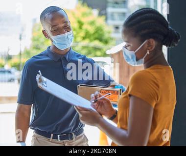 Schild, covid und schwarze Frau mit einer Lieferung an der Tür mit einem glücklichen Delivery Mann in einer Gesichtsmaske für die Sicherheit Compliance. E-Commerce, Coronavirus und Stockfoto