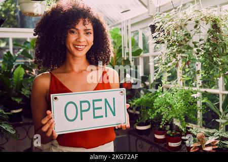 Plant shop, open sign and portrait of a woman with a small business standing in her retail nursery. Happy, smile and female entrepreneur from Brazil Stockfoto