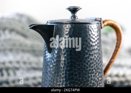 Schöne strukturierte Teekane auf einem verschwommenen Hintergrund Nahaufnahme. Stockfoto