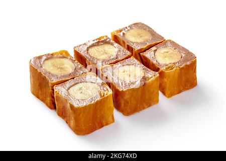 Sushi-Brötchen mit süßem Obst, gefüllt mit delikatem Schokoladenkäse und Banane, verpackt in dünnen Pfannkuchen, isoliert auf weißem Hintergrund. Japanischer Stil Stockfoto
