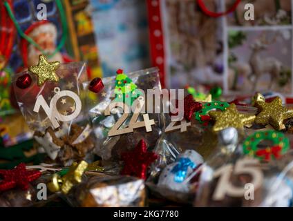 ILLUSTRATION - 21. November 2022, Berlin: Ein selbstgemachter Adventskalender mit kleinen Tüten mit Zahlen von 1 bis 24, gefüllt mit Weihnachtsgebäck und Schokolade, steht auf einem Tisch. Foto: Monika Skolimowska/dpa Stockfoto