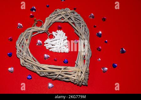 Strohherz-Figur auf rotem Hintergrund, Liebes- und Romantik-Symbole, valentinstag-Muster, hochauflösende Makroaufnahme, stilisiertes Foto. Stockfoto
