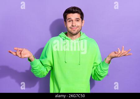 Foto von einem ahnungslosen attraktiven Kerl Keine Ahnung, wo er sein Handy vergessen hat Keine Ahnung Schultern auf violettem Hintergrund zucken Stockfoto