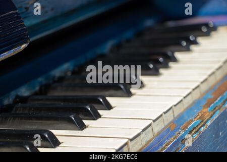 Altes Klavier mit schwarz-weißen Tasten auf der Straße als Hintergrund, Musikkonzept Stockfoto