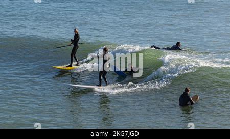 Surfer an einem schönen Tag am Bournemouth Pier, 20.. November 2022kneeling Stockfoto