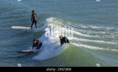 Surfer an einem schönen Tag am Bournemouth Pier, 20.. November 2022kneeling Stockfoto