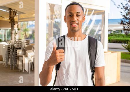 Ein junger afrikaner, der in der Stadt Daumen hoch zeigt. Stockfoto