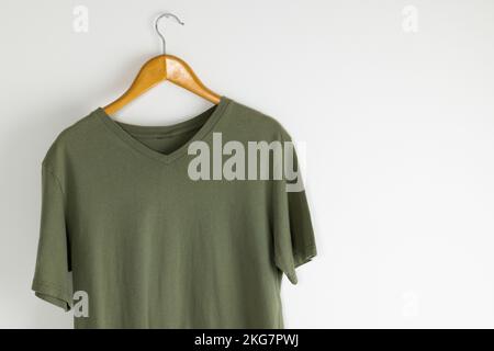 T-Shirt zum Aufhängen am Kleiderbügel und Kopierbereich auf weißem Hintergrund Stockfoto