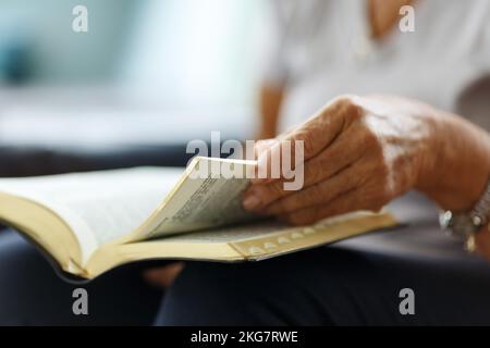 Nahaufnahme der Hände der Seniorin auf der bibel, gefaltet im Gebet Stockfoto