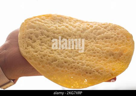 Eine Hand nimmt einen marokkanischen Pfannkuchen, Baghrir typisch marokkanisches Frühstücks-Dessert Stockfoto