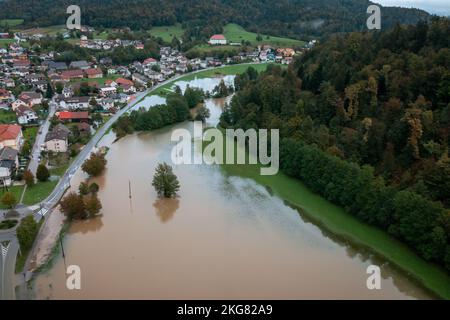 Ausgedehnte Sintflut in ganz Europa, überflutetes Bergtal, in der Nähe des Hausbereichs und der Verkehrswege, Drohne geschossen. Extremes Klimaereignis. Stockfoto