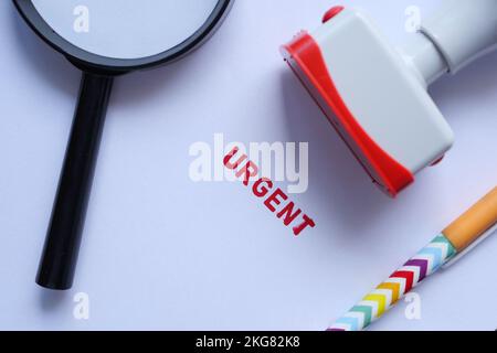 Roter STEMPEL MIT DRINGENDEM Wort auf einem Weißbuch Stockfoto