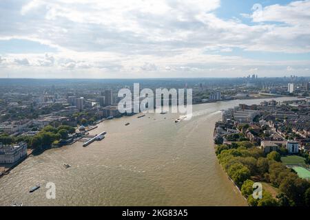 Der Verkehr auf der Themse in London, Cory zieht Lastkähne mit zitronengelben Containern, Draufsicht. Stockfoto