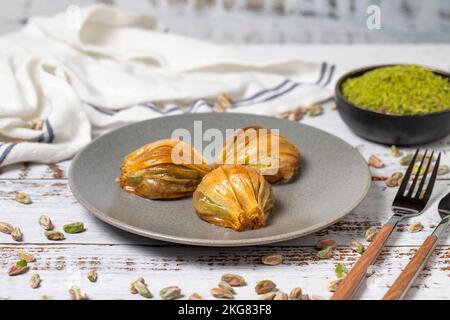 Muscheln Baklava auf weißem Holzhintergrund. Türkische Köstlichkeiten. Türkisches Baklava. Schließen Stockfoto