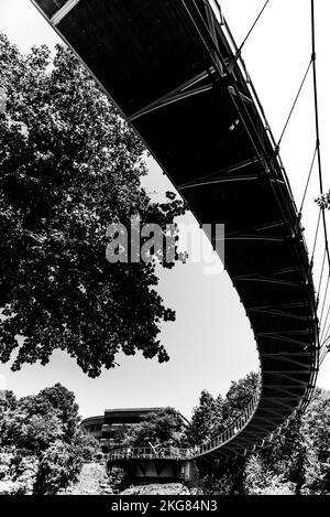 Eine vertikale Graustufenaufnahme einer Brücke im Park in Greenville, South Carolina, USA. Stockfoto