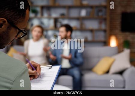 Ein Besuch bei einem Familienpsychologen für ein verheiratetes Paar. Ein afroamerikanischer Psychologe konsultiert ein unglückliches Ehepaar. Beziehung Stockfoto