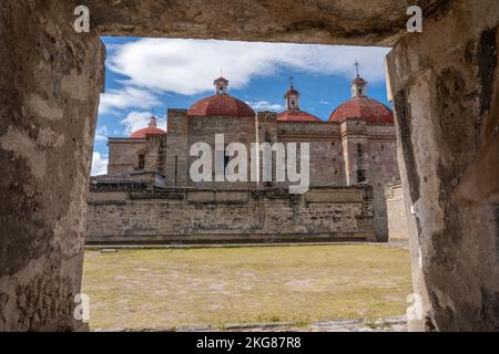 Der Tempel des San Pablo Apostol, eingerahmt von prähispanischen Zapotekenruinen in San Pablo Villa de Mitla, Oaxaca, Mexiko. Es begann 1590 und wurde gebaut Stockfoto