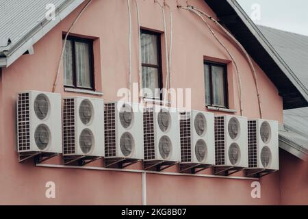 Viele Klimaanlagen sind an der Wand des Hauses befestigt Stockfoto