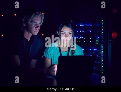 Techniker, die ein Notebook im Serverraum verwenden Stockfoto