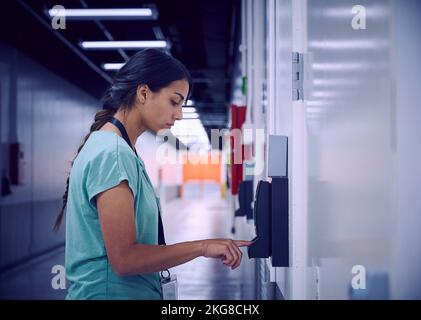 Frau mit digitalem Fingerabdruckscanner im Büro Stockfoto