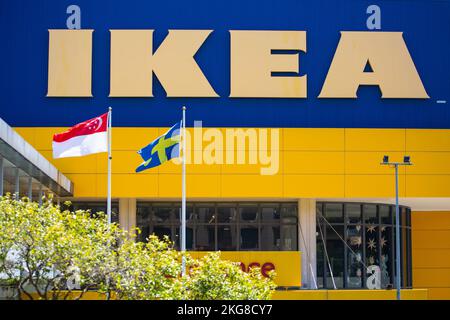 Nahaufnahme des Ikea Möbelgebäudes und der Flagge von Singapur und Schweden. Stockfoto
