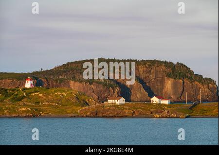 Kanada, Labrador, Neufundland, Trinity, Meeresküste mit entferntem Leuchtturm Fort Point bei Sonnenuntergang