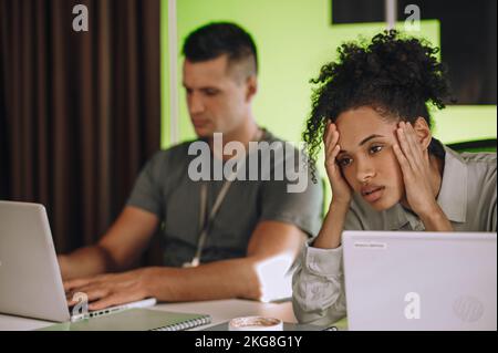 Weibliche Mitarbeiterin mit Schmerzen in den Tempeln Stockfoto