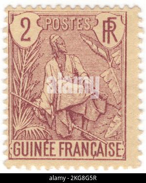 FRANZÖSISCH-GUINEA - 1904: Eine 2 Centimes violett-braun auf Buff Briefmarke, die Fulah Shepherd zeigt. Die Fula, Fulani oder Fulah sind eine der größten ethnischen Gruppen in der Sahelzone und Westafrika, die weit über die Region verstreut sind. Sie leben in vielen Ländern und leben hauptsächlich in Westafrika und nördlichen Teilen Zentralafrikas, im Südsudan, in Darfur und in Regionen nahe der Küste des Roten Meeres im Sudan. Die ungefähre Anzahl der Fula-Menschen ist aufgrund von kollidativen Definitionen bezüglich der ethnischen Zugehörigkeit von Fula unbekannt. Nach verschiedenen Schätzungen liegen die Zahlen weltweit zwischen 25 und 40 Millionen Menschen Stockfoto