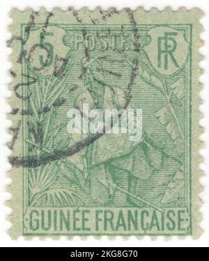 FRANZÖSISCH-GUINEA - 1904: Ein 5 Centimes Grün auf grünlicher Briefmarke, die Fulah Shepherd zeigt. Die Fula, Fulani oder Fulah sind eine der größten ethnischen Gruppen in der Sahelzone und Westafrika, die weit über die Region verstreut sind. Sie leben in vielen Ländern und leben hauptsächlich in Westafrika und nördlichen Teilen Zentralafrikas, im Südsudan, in Darfur und in Regionen nahe der Küste des Roten Meeres im Sudan. Die ungefähre Anzahl der Fula-Menschen ist aufgrund von kollidativen Definitionen bezüglich der ethnischen Zugehörigkeit von Fula unbekannt. Nach verschiedenen Schätzungen liegen die Zahlen weltweit zwischen 25 und 40 Millionen Menschen Stockfoto