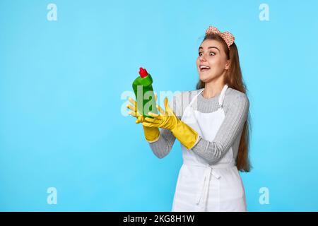 Eine Frau in Gummihandschuhen fängt eine fliegende Flasche Waschmittel Stockfoto